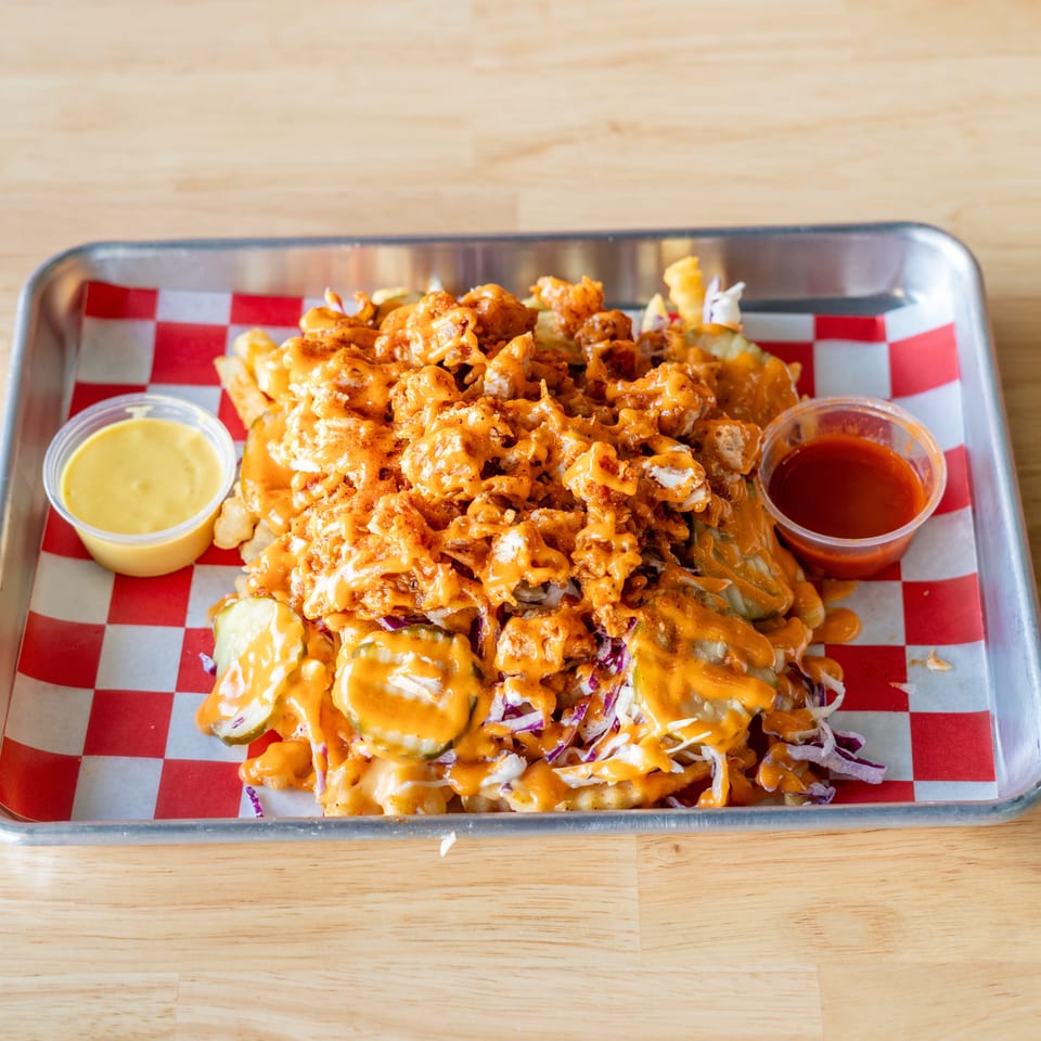 Loaded fries with crispy chicken, pickles, coleslaw, and orange sauce, served with two dipping sauces.