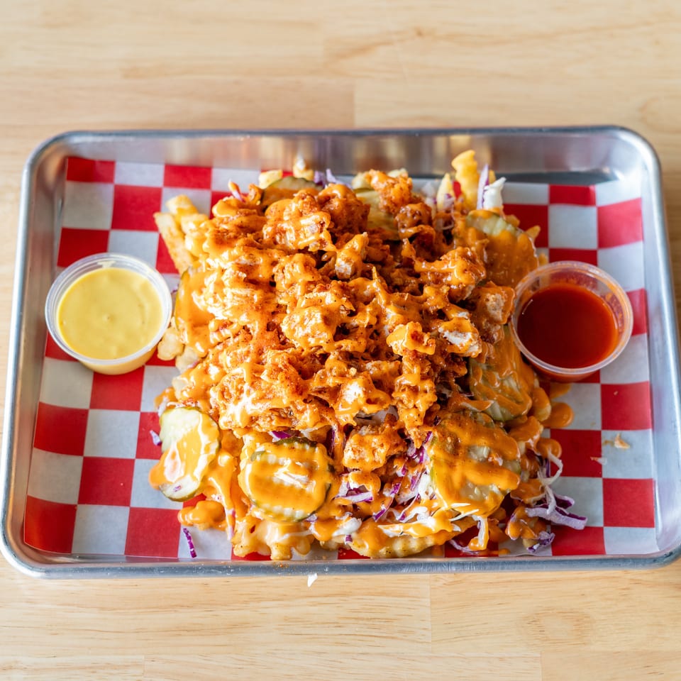 Loaded fries with crispy chicken, pickles, coleslaw, and orange sauce, served with two dipping sauces.